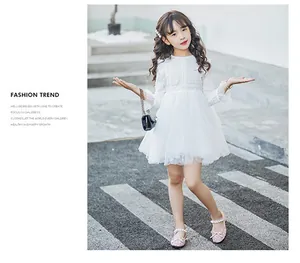 Elegant girl in white lace tulle dress and pink glittery bow princess shoes walking on crosswalk