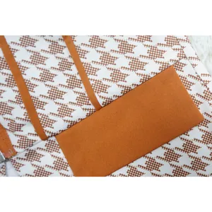 Detalle del estampado de pata de gallo y el cuello esmoquin naranja en un traje nuevo