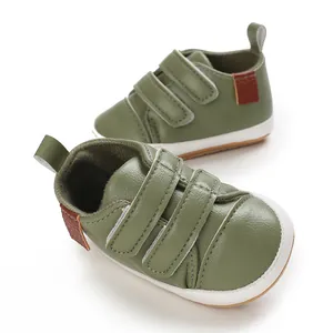 Close-up detail of green baby walking shoes with non-slip rubber soles and velcro strap