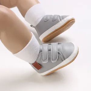 Detailed side view of grey baby walking shoes featuring velcro straps and white sole