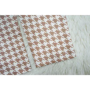 Primer plano de los bajos del pantalón con estampado de pata de gallo marrón y blanco