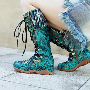 Detailansicht der Vintage-Stiefel mit türkisfarbener Rosenprägung und Strickelementen