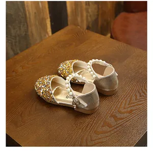Vue détaillée des chaussures de princesse dorées à strass avec bride de perles élégantes