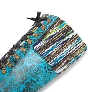 Detailansicht von geprägtem Blumenleder und bunter Stricktextur an Schnürstiefeln
