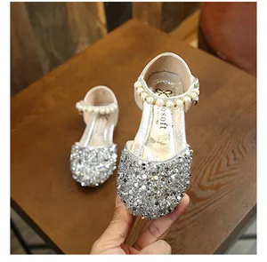 Gros plan de chaussures de princesse argentées pour filles avec strass et perles