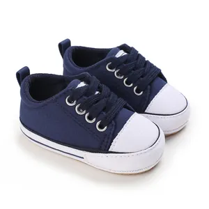 Detail view of navy blue baby canvas shoes with white toe caps and soft toddler soles