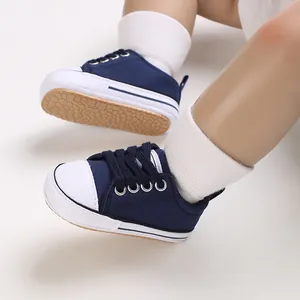 Detailed close-up of navy blue baby canvas sneakers with white socks and soft non-slip soles.