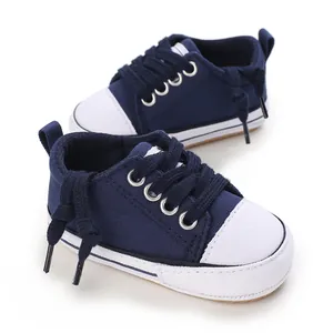 Detailed macro view of navy blue baby canvas sneakers with soft white soles for infants