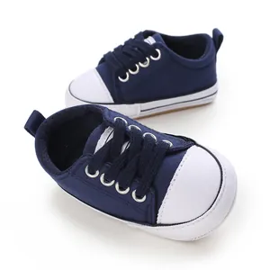 Close-up of navy blue baby canvas sneakers with soft white rubber-like soles