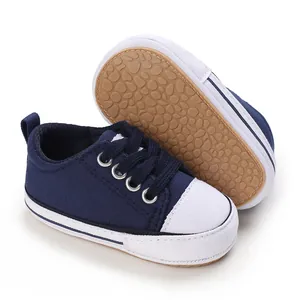 Detail view of navy blue baby canvas sneakers with non-slip soft rubber sole texture