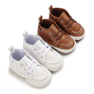 Detail view of soft-soled baby walker shoes in white and brown faux leather material