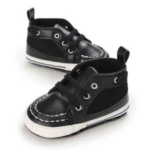 Detailed view of black baby walking shoes with soft soles and white contrast stitching.