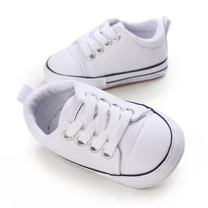 Macro view of white soft-soled baby canvas walking shoes