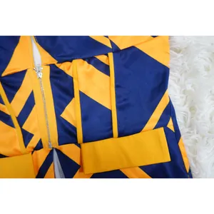 Detalle de cerca que muestra la cremallera de un traje con estampado geométrico azul y amarillo