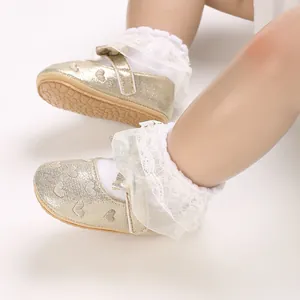 Detail view of gold glitter baby princess shoes with lace trim and heart pattern