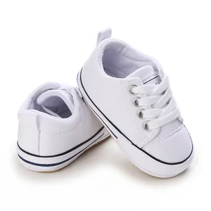 Classic white baby canvas shoes with soft soles, perfect for infants learning to walk.