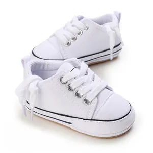 Detailed view of white soft-soled baby canvas sneakers for infants 3-12 months old