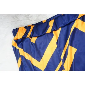 Primer plano de la cintura elástica de unos pantalones con estampado azul y naranja