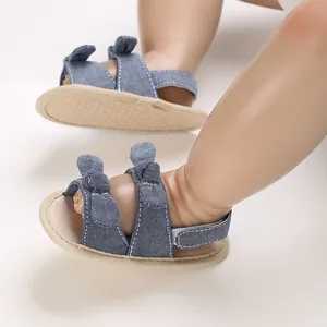 Close-up van blauwe denim baby sandalen met zachte zolen en schattige strikdetails