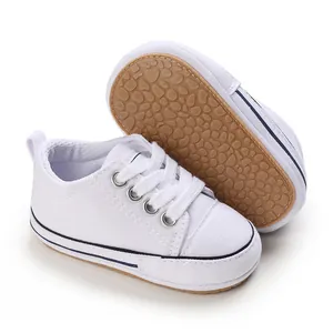 Detail view of white canvas baby pre-walker shoes with soft anti-slip pebbled sole