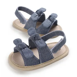 Detailed view of blue denim baby walking sandals featuring soft soles and cute bows