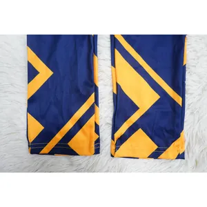 Primer plano detallado que muestra el patrón geométrico azul y amarillo en los bajos del pantalón.
