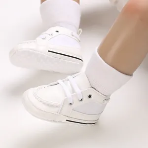 Macro detail of white soft-soled baby walking shoes featuring a lace-up design