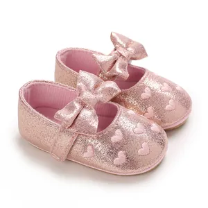 Detailed view of pink glittery baby walker shoes with heart embroidery and bow