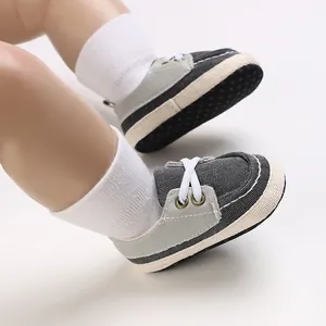 Nahaufnahme von Baby-Lauflernschuhen mit weicher Canvas-Sohle und grauem Patchwork-Design