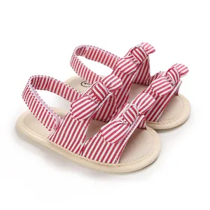 Close-up van rood gestreepte babysandalen met een schattige strik en zachte zool