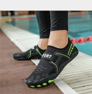 Primo piano di scarpe acquatiche nere e verdi ad asciugatura rapida sul bordo piscina