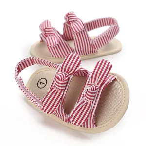 Gedetailleerde weergave van rood-wit gestreepte babysandalen met schattig strikje