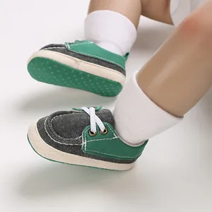Nahaufnahme von grünen und grauen weichen Baby-Leinwand-Laufschuhen für Neugeborene
