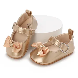 Detailed view of metallic gold baby walker shoes with ribbon bow and buckle strap