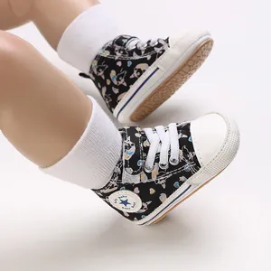 Nahaufnahme von schwarzen Baby-Lauflernschuhen mit bunten Herz- und Hundemustern.