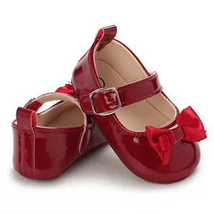 Detail view of shiny red baby princess walking shoes with a satin bow and silver buckle.