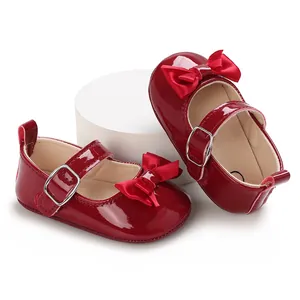 Detail showing red patent leather baby shoes with satin bow and buckle strap
