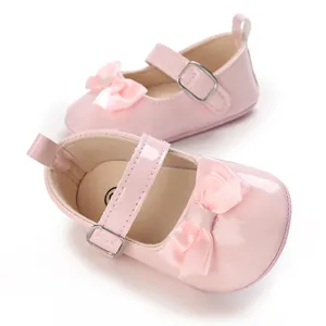Detail view of pink patent leather baby girl walker shoes with bow detail