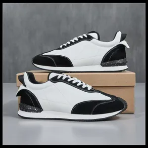Vue de profil de baskets rétro en cuir noir et blanc avec détail moucheté au niveau du talon