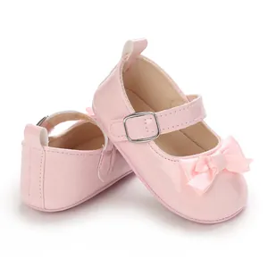 Close-up of pink patent leather baby walking shoes with bow and buckle strap detail