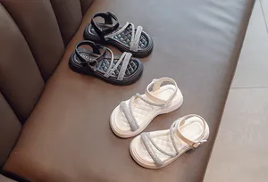 Detailed view of stylish girls' rhinestone Roman sandals in black and beige colors
