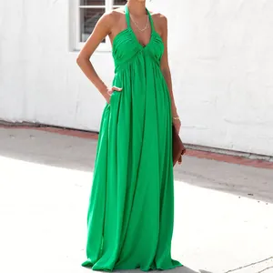 Vista laterale dell'elegante abito lungo verde con tasche e profondo scollo a V stile halter
