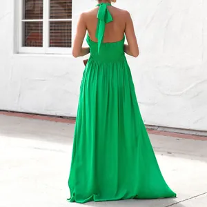 Vista posteriore di un maxi abito verde allacciato al collo con smock