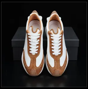 Vue de dessus symétrique de baskets en cuir pour hommes blanc et marron suédé