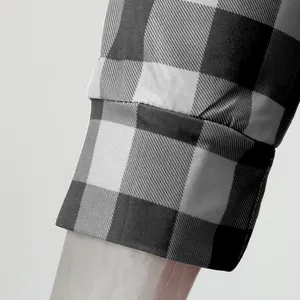 Nahaufnahme der weichen Stoffstruktur und der schwarz-weiß karierten Pyjama-Ärmelmanschette
