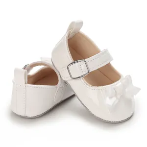 Detailed macro view of white infant Mary Jane shoes featuring a satin bow and soft sole