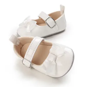 High-quality close-up of white infant Mary Jane walking shoes with elegant bow detail