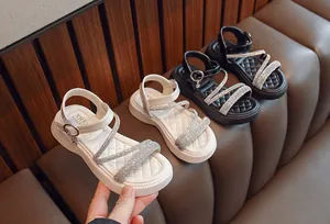 Detailed view of girls' Roman sandals with sparkling rhinestones and soft quilted soles.