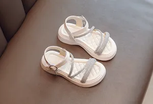 Top view of girls' white Roman sandals with rhinestone cross straps and soft sole