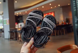 Detail of black girl's sandals with glittering rhinestone straps and quilted insole.